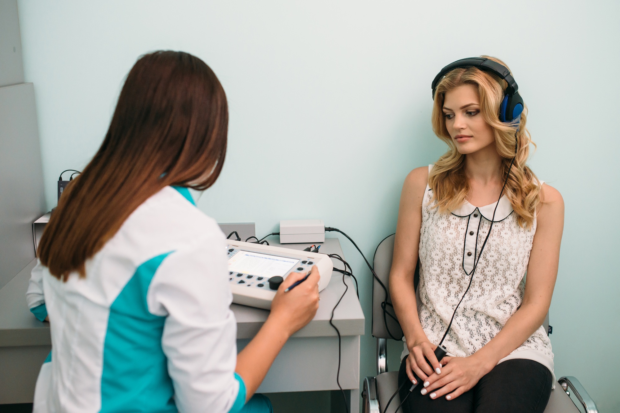Audiologist conducting hearing test with a patient in a clinical setting