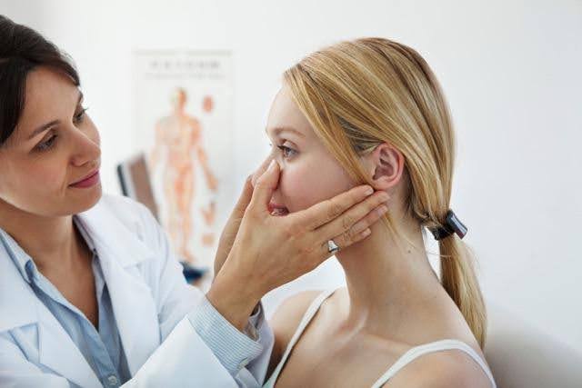 A doctor examines a woman face during a medical consultation