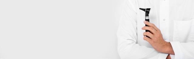 A man wearing a white coat is holding a razor indicating a role in grooming or medical care