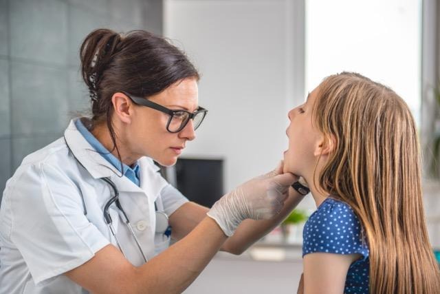 A doctor examines a woman in a medical office focusing on her health