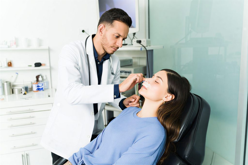 A man receives a dental cleaning from a woman in a clinical setting