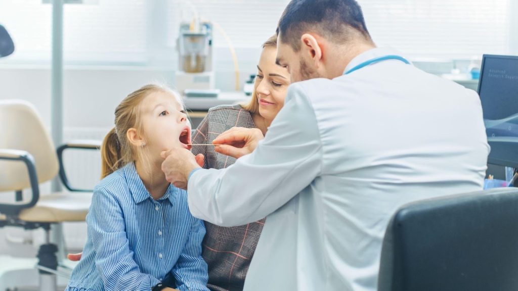 A young girl receives a medical examination from a doctor in a clinical setting