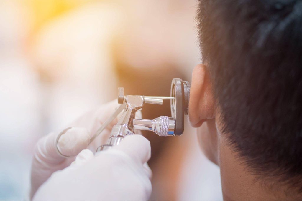 A doctor checks a man ears ensuring his hearing health in a medical office
