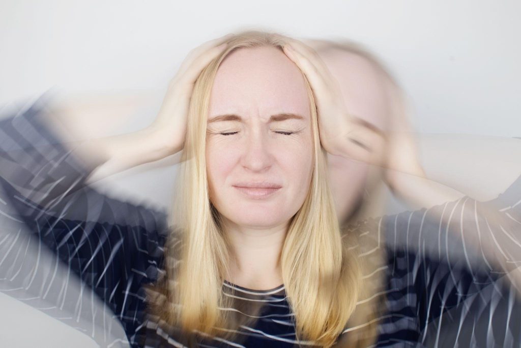 A woman with her hands on her head indicating frustration or deep thought