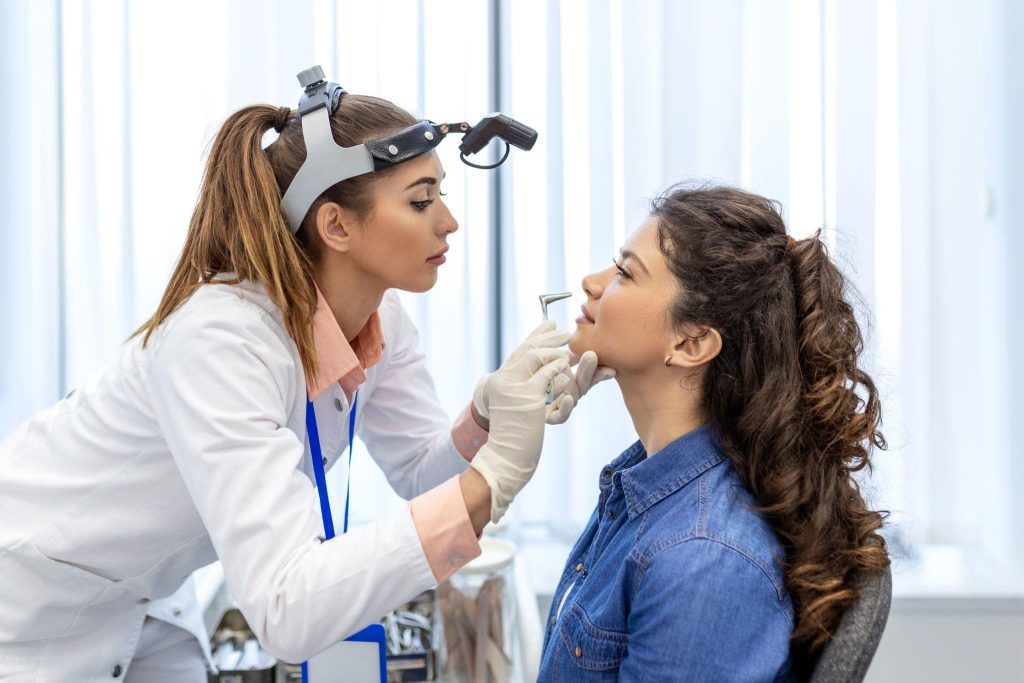 A woman receiving a dental examination from a doctor checking her teeth